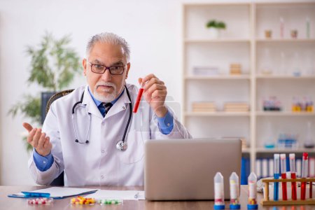 Téléchargez les photos : Vieux médecin pharmacien dans le concept de synthèse des médicaments - en image libre de droit
