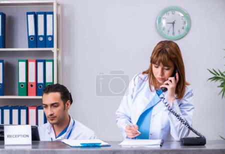 Téléchargez les photos : Les deux médecins travaillant à la réception de l'hôpital - en image libre de droit