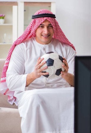 Foto de El hombre de negocios árabe viendo la televisión en casa - Imagen libre de derechos