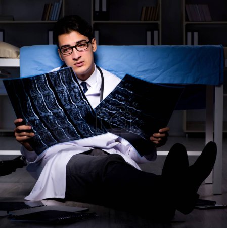Téléchargez les photos : Le médecin travaillant de nuit à l'hôpital après de longues heures - en image libre de droit