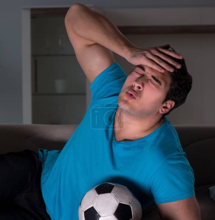 Photo for The young man watching football late at night - Royalty Free Image