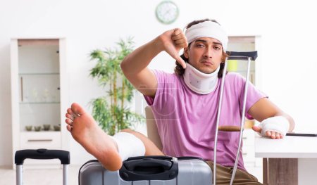 Photo for The young injured man preparing for the trip - Royalty Free Image