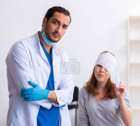 Foto de Mujer joven lesionada visitando joven médico masculino - Imagen libre de derechos
