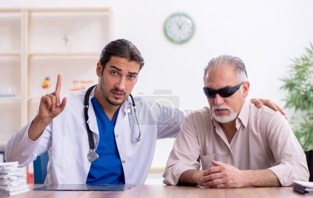Foto de Viejo visitando joven doctor masculino - Imagen libre de derechos
