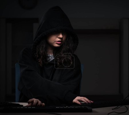 Téléchargez les photos : La femme pirate piratage pare-feu de sécurité tard dans le bureau - en image libre de droit