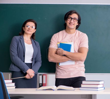 Photo for The old female teacher and male student in the classroom - Royalty Free Image