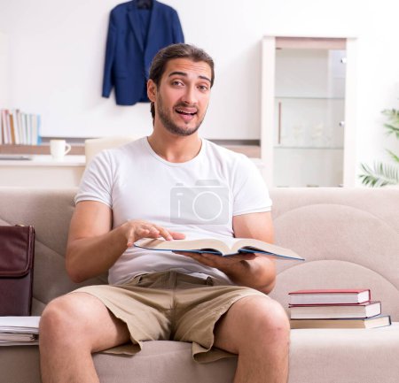Photo for The young male student preparing for exams at home - Royalty Free Image