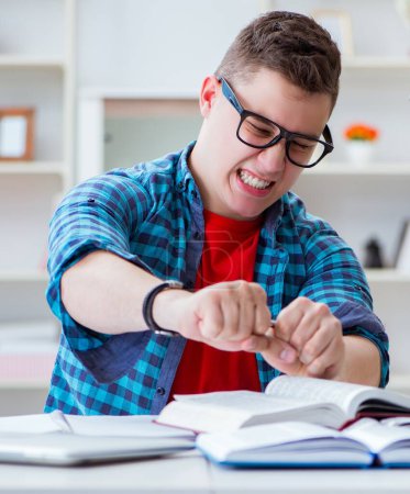 Foto de El adolescente joven que se prepara para los exámenes que estudian en un escritorio en el interior - Imagen libre de derechos