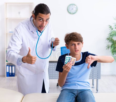 Photo for The young male doctor examining boy in the clinic - Royalty Free Image