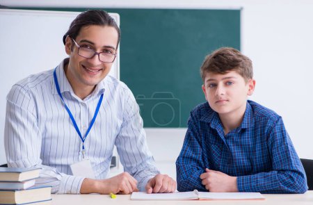 Téléchargez les photos : Le jeune professeur masculin et le garçon dans la salle de classe - en image libre de droit