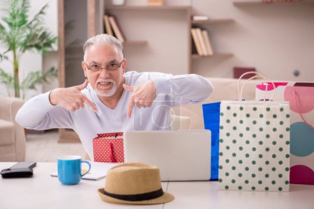 Photo for Old man with many bags in Christmas concept indoors - Royalty Free Image
