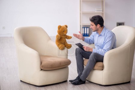 Foto de Joven psicólogo reunión con oso de juguete - Imagen libre de derechos
