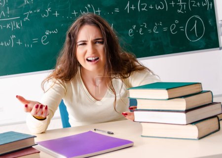 Photo for The young female math teacher in front of chalkboard - Royalty Free Image