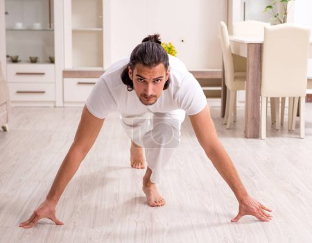 Photo for The young man doing physical exercises at home - Royalty Free Image