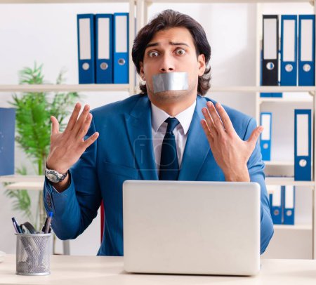 Foto de El joven empleado con cinta adhesiva en la boca - Imagen libre de derechos