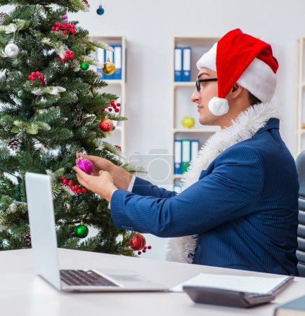 Téléchargez les photos : L'homme d'affaires célébrant les vacances de Noël dans le bureau - en image libre de droit