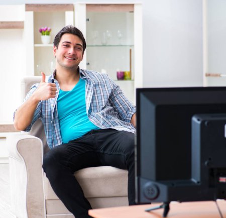 Téléchargez les photos : L'homme qui regarde la télé à la maison - en image libre de droit