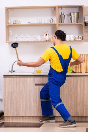 Téléchargez les photos : Le jeune entrepreneur masculin réparer robinet à la maison - en image libre de droit