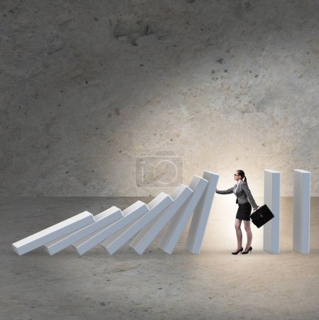 The businesswoman preventing domino effect in business concept