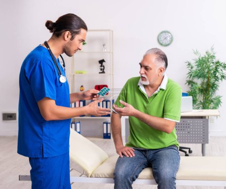 Photo for The old man visiting young male doctor gastroenterologist - Royalty Free Image