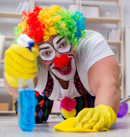 Téléchargez les photos : Le clown drôle faisant le nettoyage à la maison - en image libre de droit