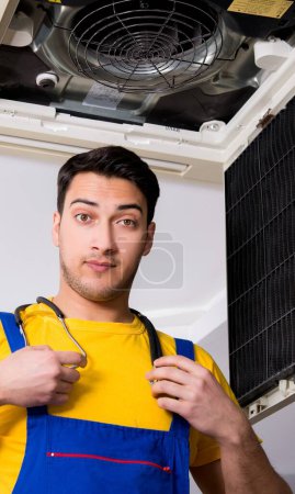 Téléchargez les photos : Le réparateur réparer unité de climatisation de plafond - en image libre de droit