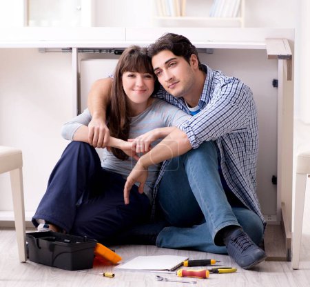 Téléchargez les photos : L'homme et la femme assemblant des meubles à la maison - en image libre de droit