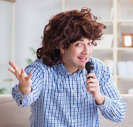 Téléchargez les photos : L'homme drôle chantant des chansons dans le karaoké à la maison - en image libre de droit