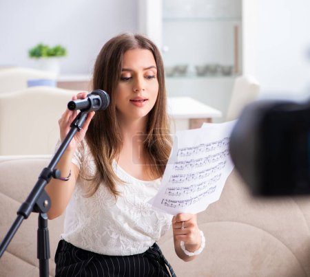 Téléchargez les photos : La belle blogueuse chantant à la maison - en image libre de droit