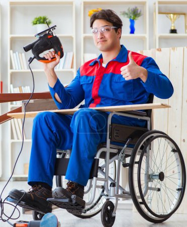 Téléchargez les photos : L'homme handicapé travaillant avec une scie circulaire - en image libre de droit