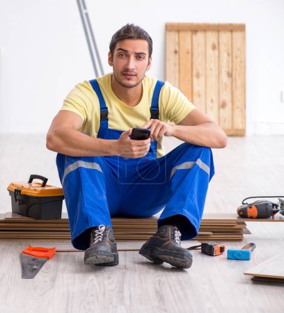 Photo for The young male contractor working indoors - Royalty Free Image