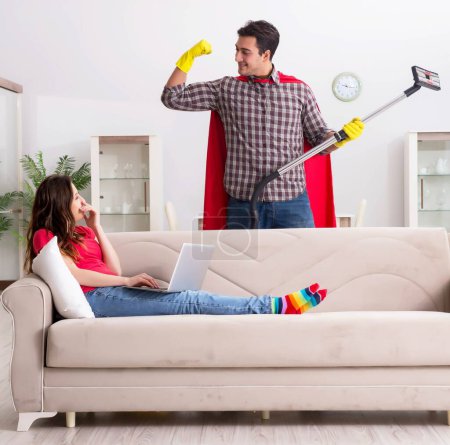 Foto de El marido superhéroe ayudando a su esposa en casa - Imagen libre de derechos