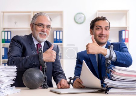 Téléchargez les photos : Les deux employés masculins mécontents du travail excessif - en image libre de droit