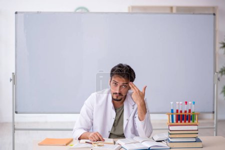 Young chemist teacher in front of whiteboard