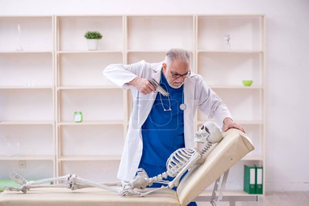 Photo for Old male doctor and skeleton patient at the hospital - Royalty Free Image