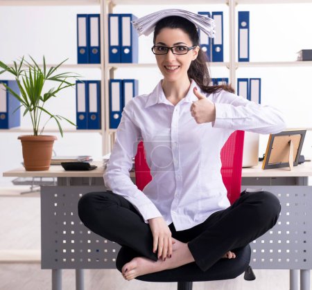 Téléchargez les photos : La jeune employée fait des exercices au bureau - en image libre de droit