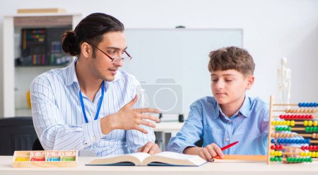 Téléchargez les photos : Le jeune père aide son fils à se préparer à l'examen - en image libre de droit