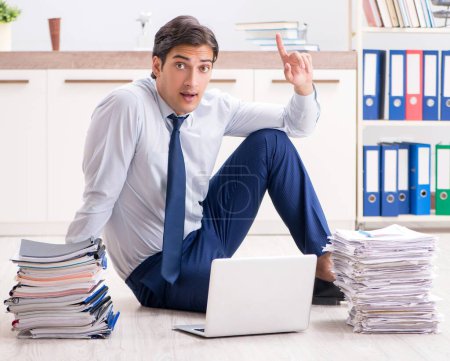 Téléchargez les photos : L'employé extrêmement occupé qui travaille au bureau - en image libre de droit