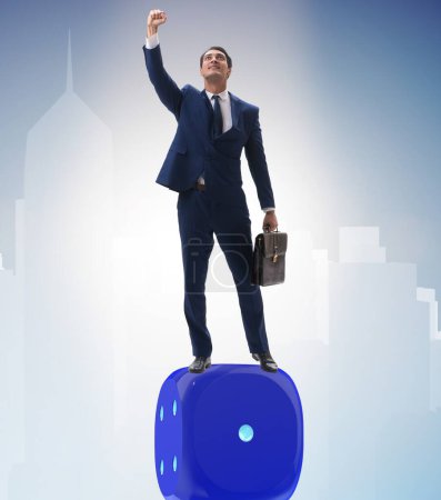 Photo for Businessman balancing on top of dice stack in uncertainty concept - Royalty Free Image