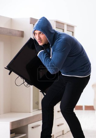 Foto de El hombre ladrón robando televisor de la casa - Imagen libre de derechos