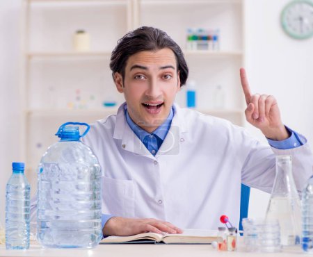 Foto de El joven químico masculino experimentando en el laboratorio - Imagen libre de derechos