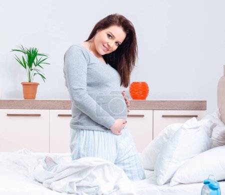 Téléchargez les photos : La jeune femme enceinte dans la chambre - en image libre de droit