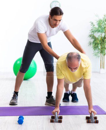 Photo for The old man doing exercises indoors - Royalty Free Image