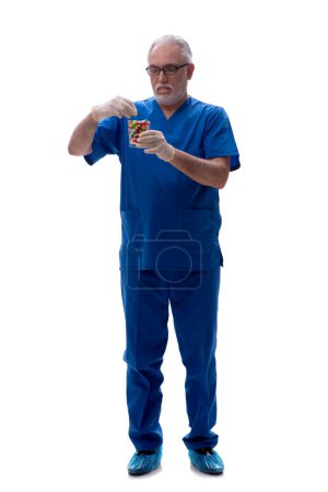 Foto de Viejo doctor sugiriendo pastillas aisladas en blanco - Imagen libre de derechos