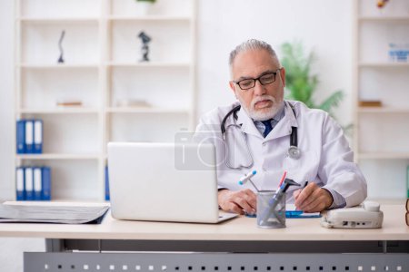 Photo for Old doctor working at the hospital - Royalty Free Image