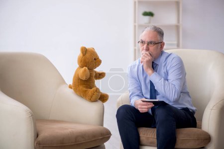 Téléchargez les photos : Vieux psychologue et ours doux dans la chambre - en image libre de droit