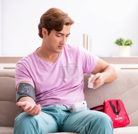 Téléchargez les photos : Le malade à la maison avec sa trousse de premiers soins - en image libre de droit