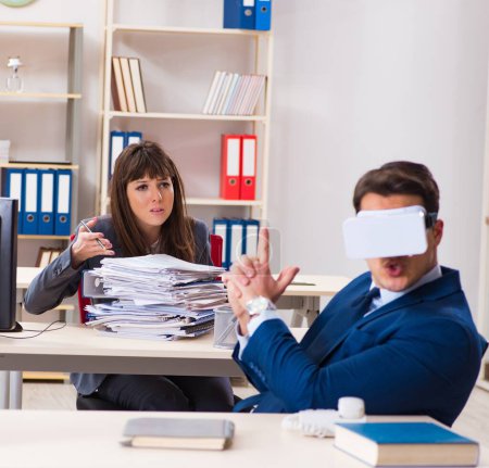 Téléchargez les photos : L'employé avec des lunettes de réalité virtuelle au bureau - en image libre de droit