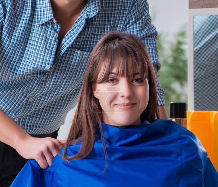 Téléchargez les photos : L'homme coiffeur homme faisant coupe de cheveux pour femme - en image libre de droit
