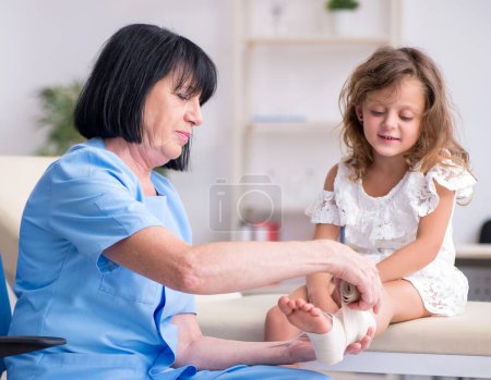 Photo for The little girl visiting old female doctor - Royalty Free Image